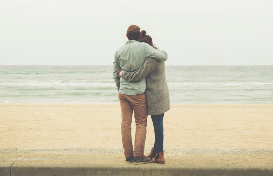 Couple on a beach looking at the sea